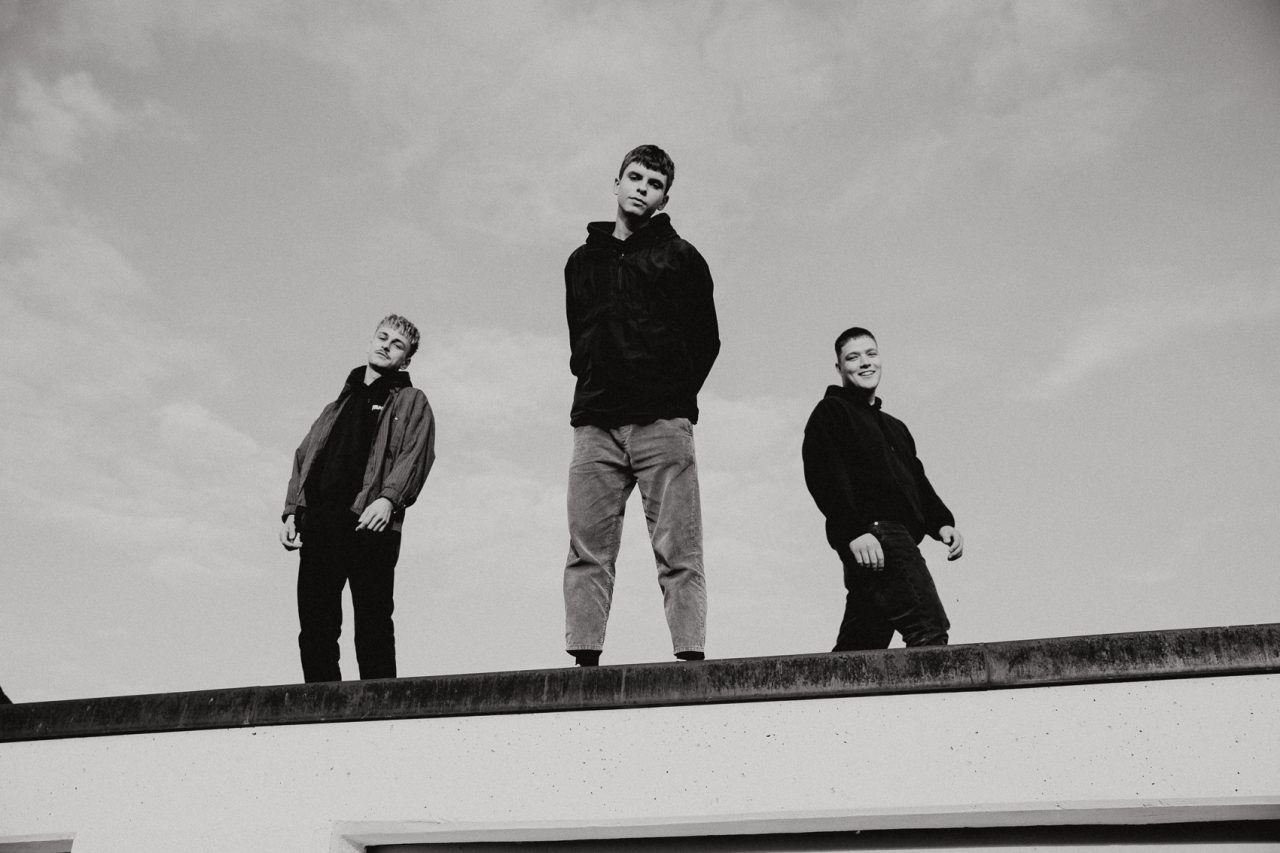 Die drei Jungs der Band VAN HOLZEN stehen auf einem Dach