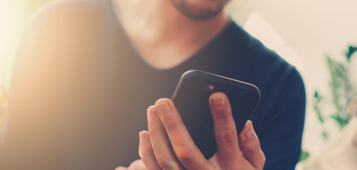 Ein Mann hält ein Smartphone in der Hand