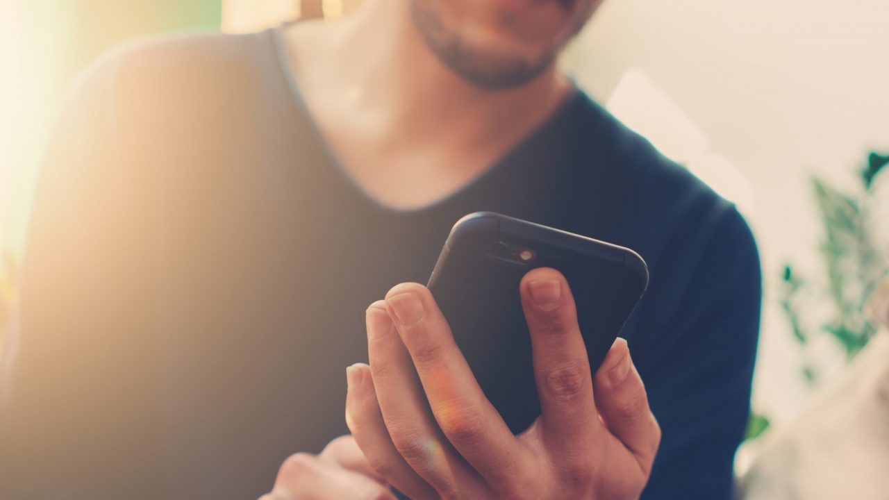 Ein Mann hält ein Smartphone in der Hand