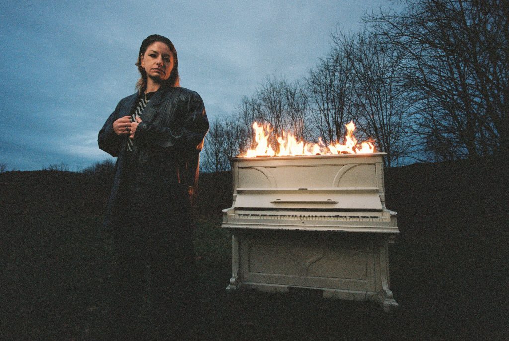 Isabella von MOLA vor einem brennenden Klavier.